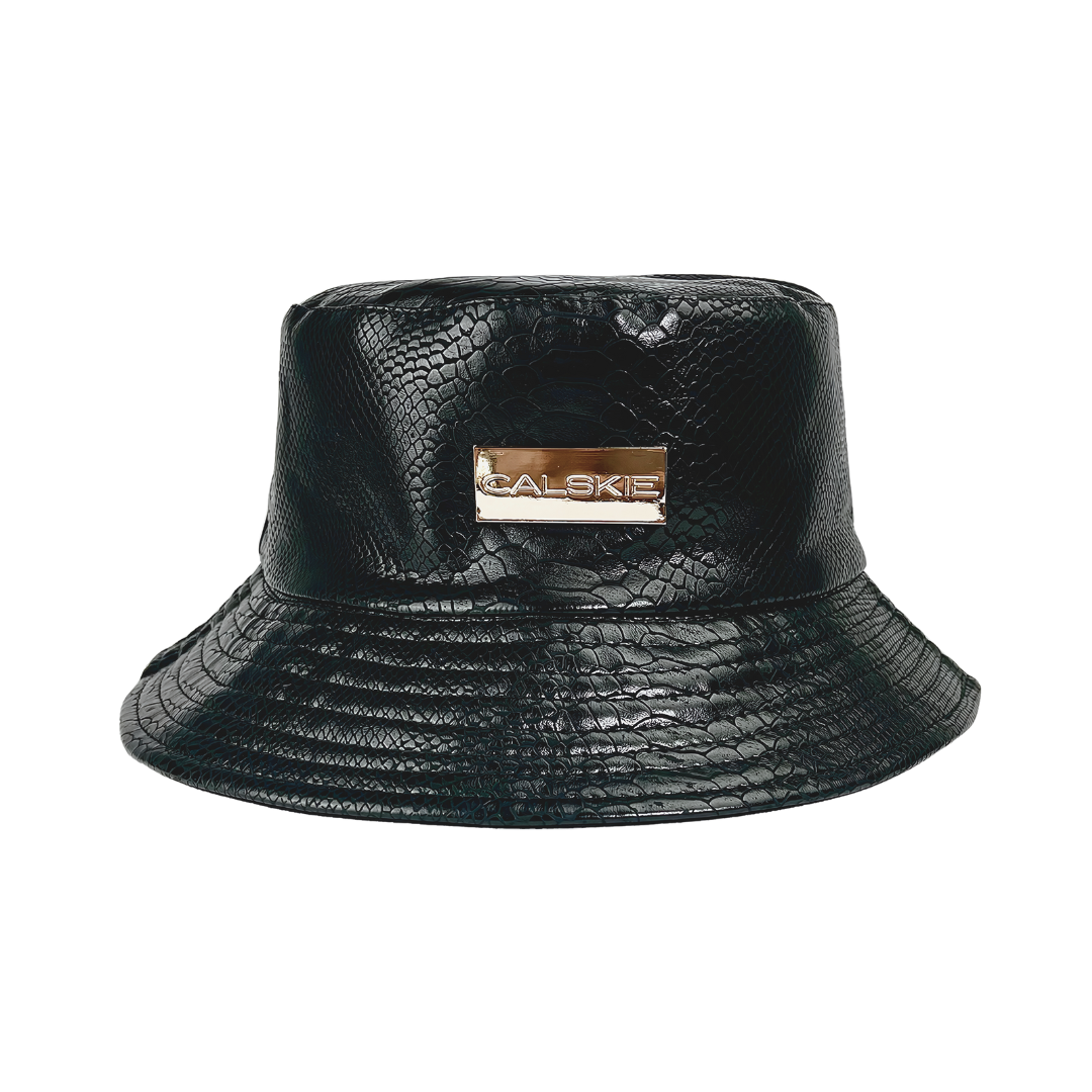 An image showing the black crocodile pattern leather bucket hat by Calskie, featuring the gold Calskie logo on the front.